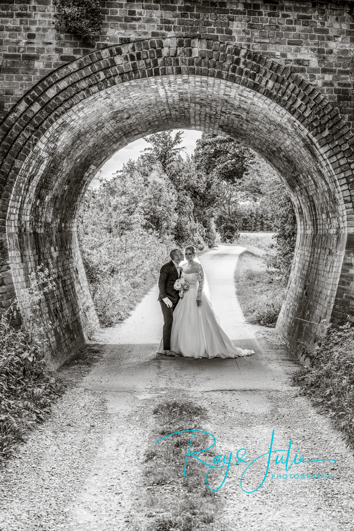 Bride and Groom under archway in Black and white. Near Saltmarshe Hall.