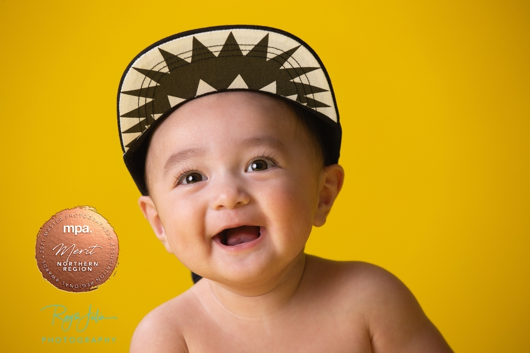 Award winning child studio portrait with bright yellow background.