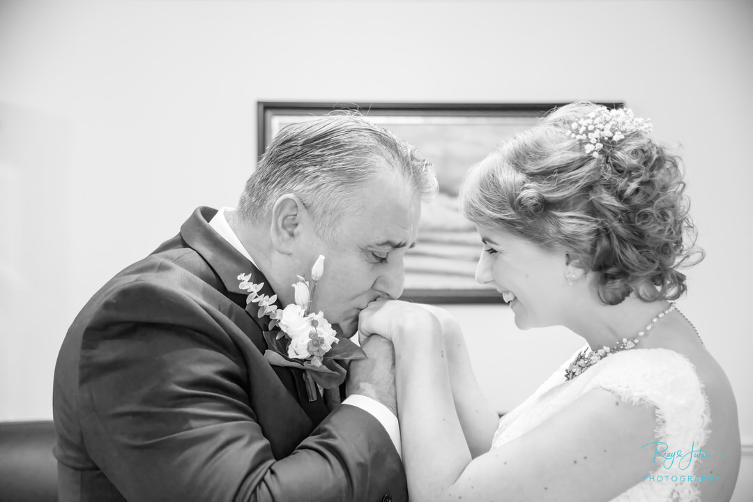 A very proud father of the bride, kissing his daughters hand. Black and white photo