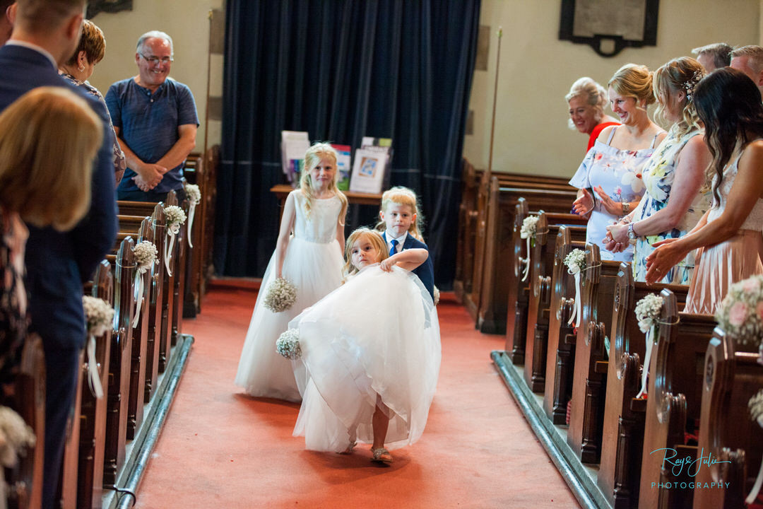 Flower girl stealing the show walking down the isle in church.