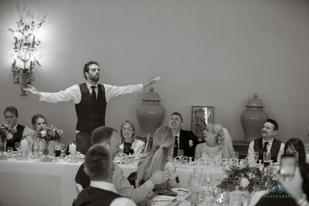 Best man taking the applause after his speech at Tickton Grange Hotel. Black and white photo