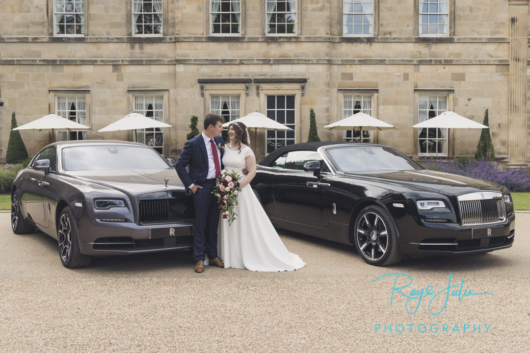 Wedding couple stood next to two Rolls Royce's outside Grantley Hall