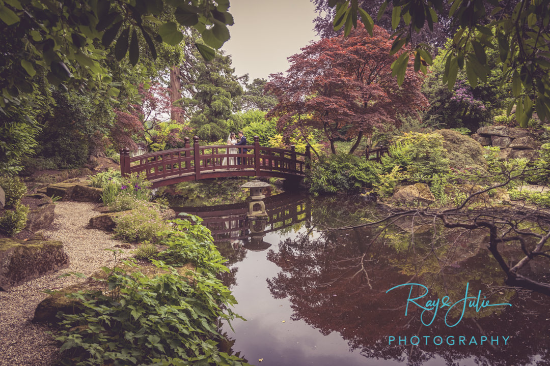 Bride and groom on bridge in the Japanese garden at Grantley Hall