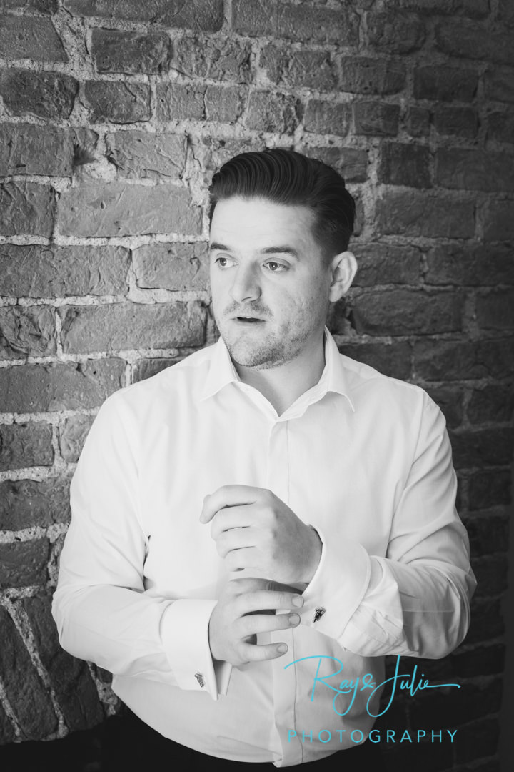 Groom getting ready in black and white in the cottage at Saltmarshe Hall