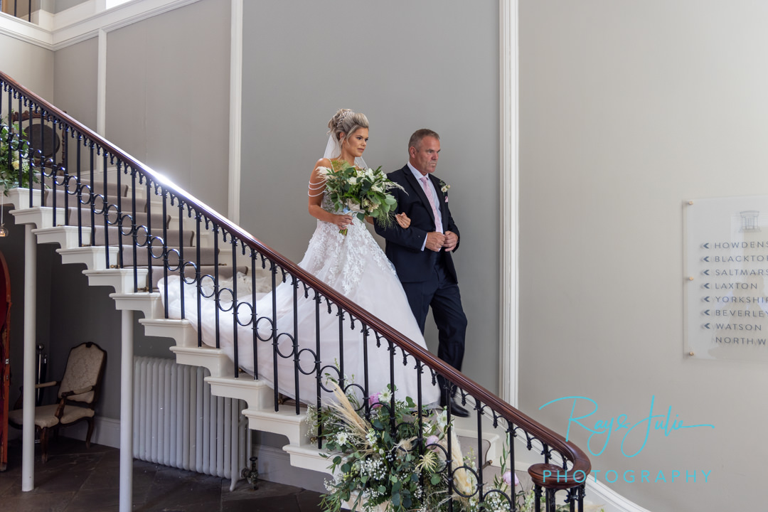 Bride and Father coming down the stairs at Saltmarshe Hall going to the wedding ceremony.