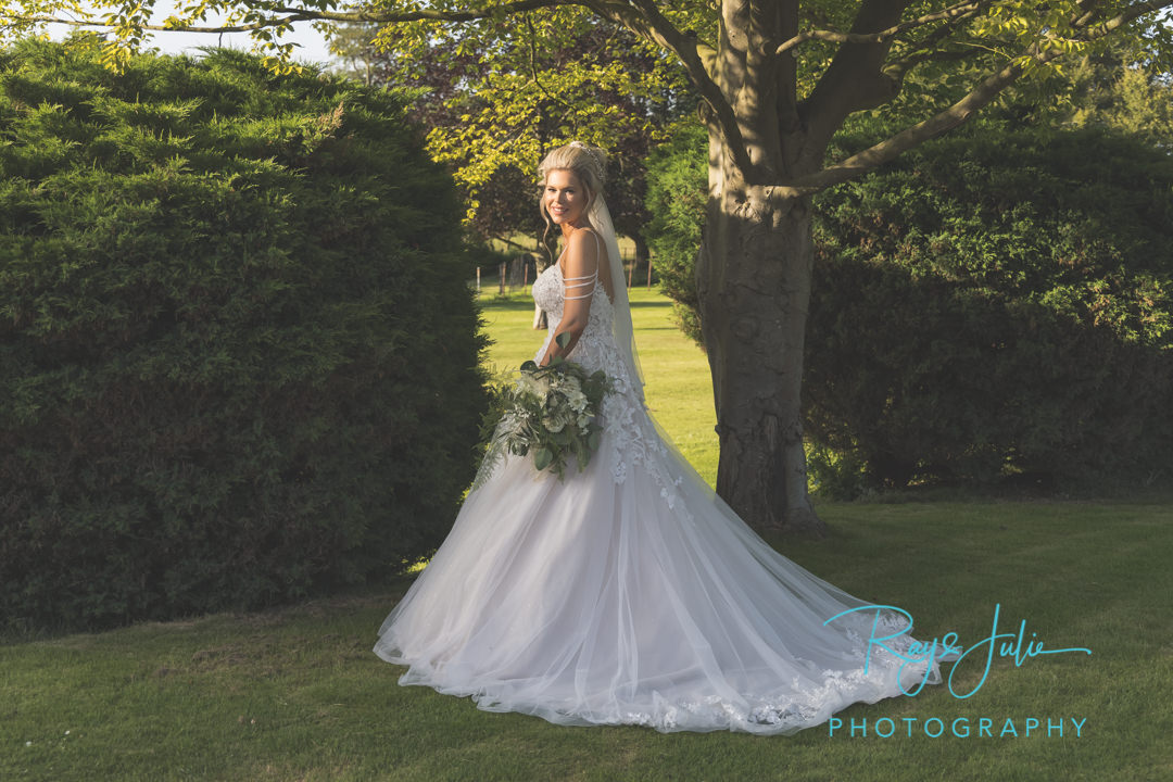 Stunning bride in beautiful wedding dress from Jane's Bridal Wear in the grounds at Saltmarshe Hall