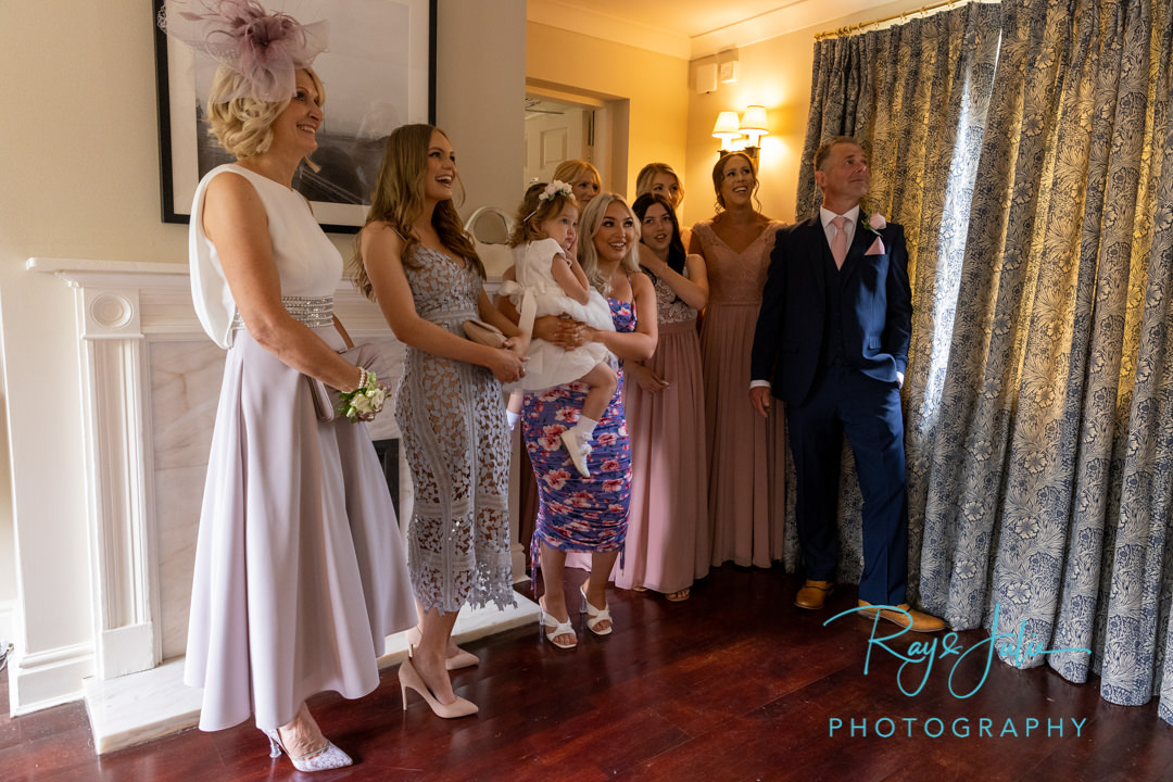 Bridal party waiting for bride to come down the stairs