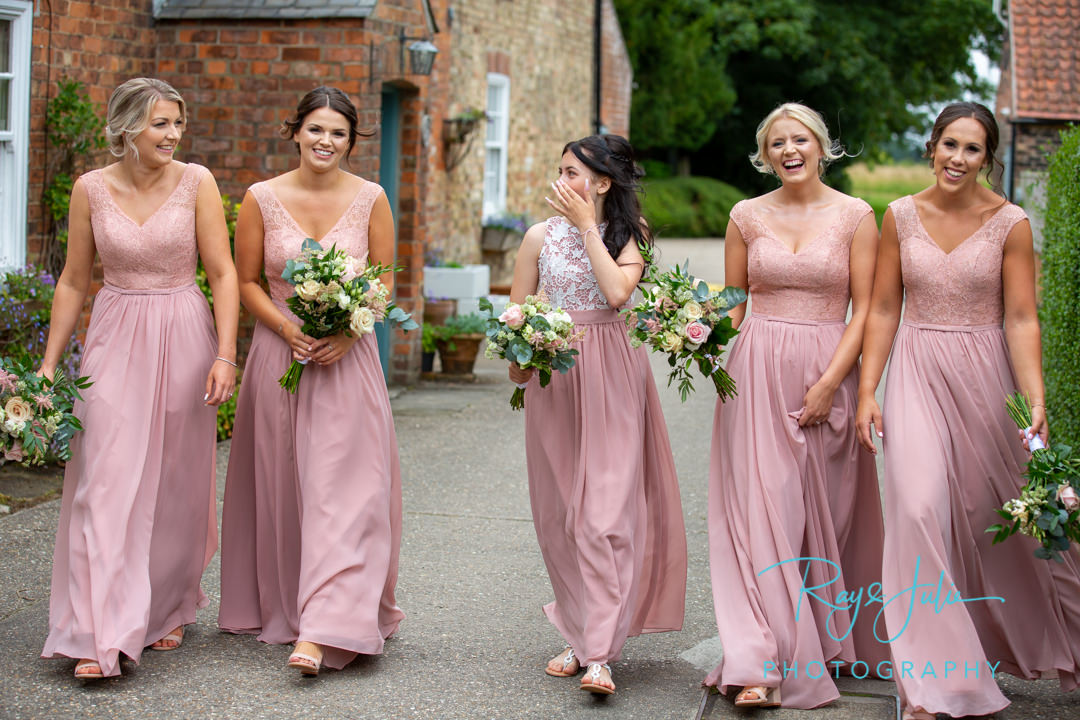 Bridesmaids laughing and smiling whilst walking