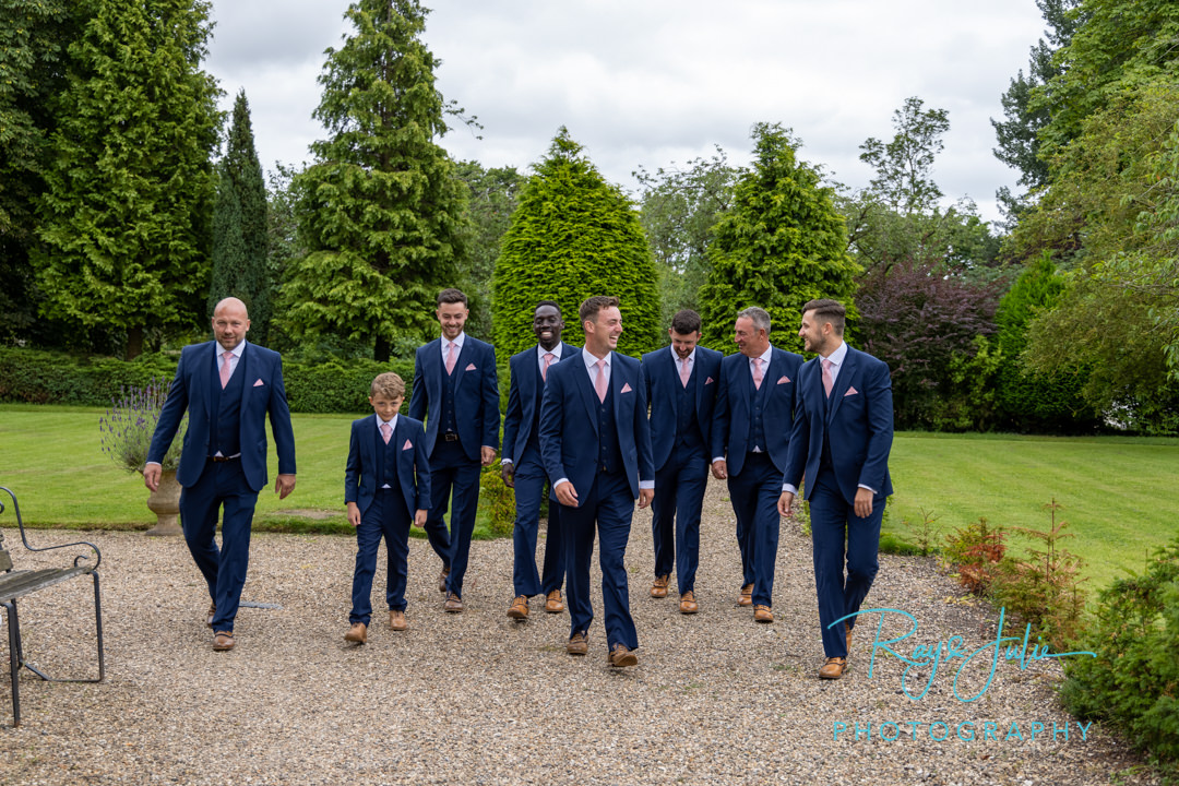 Groom and groomsmen walking having a laugh