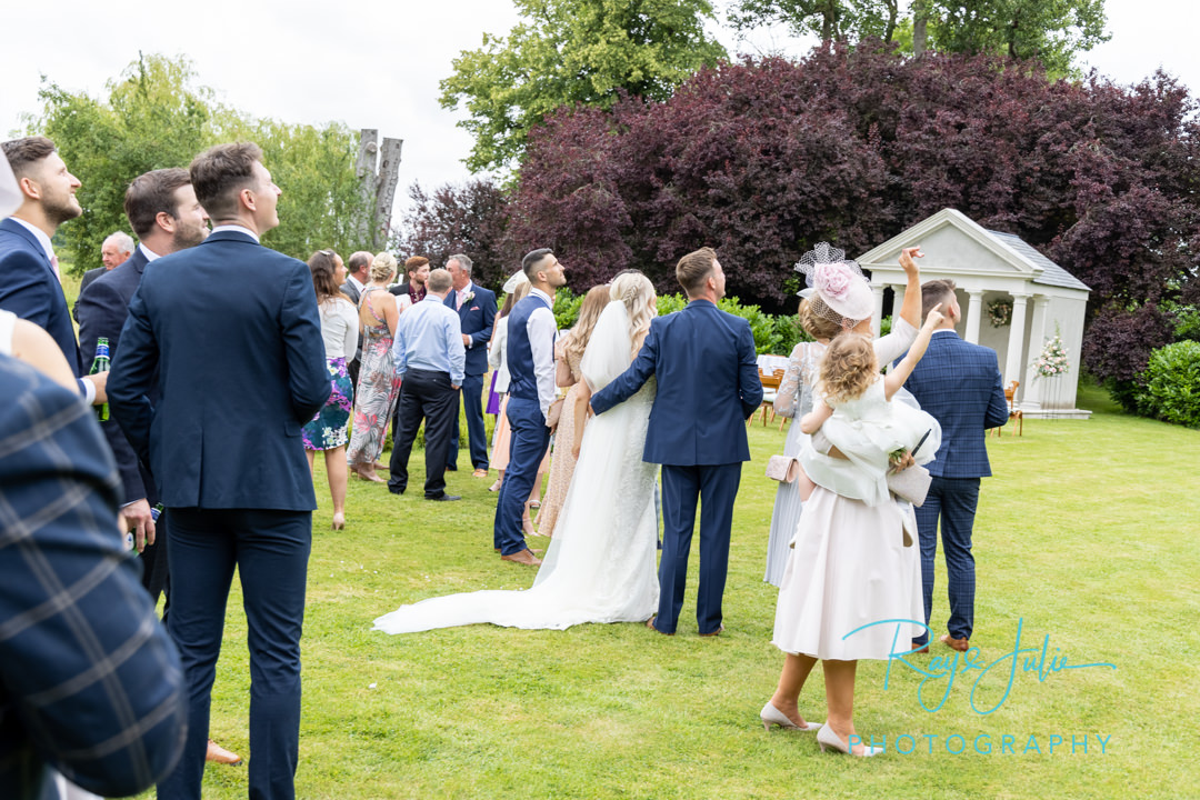 Bridal party watching a flyby of a friend in his vintage plane