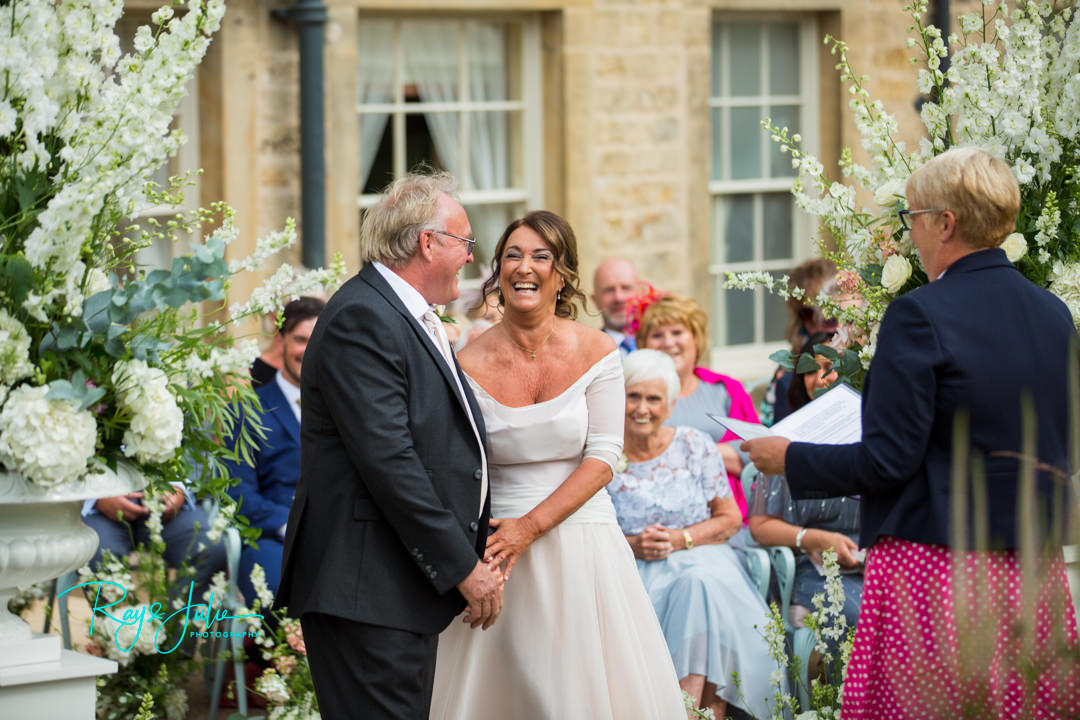 Bride and Groom laughing together during the wedding ceremony at Grantley Hall