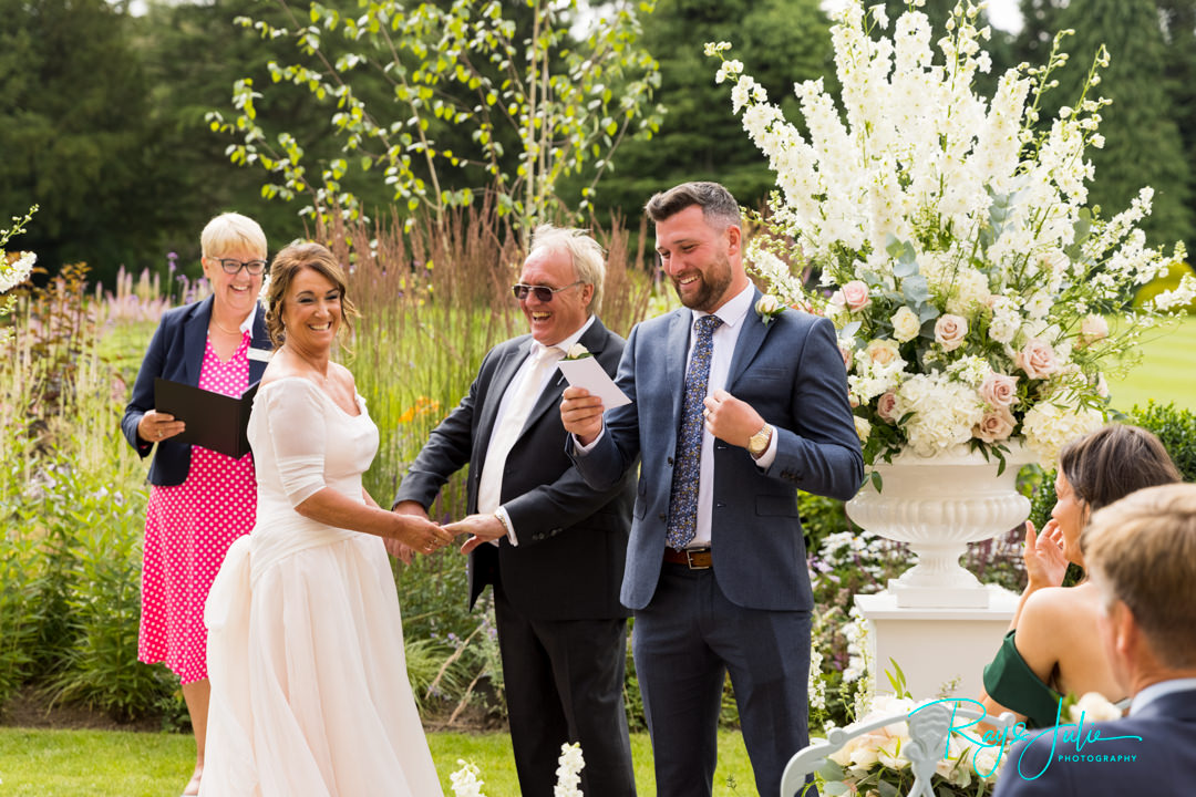 Bride and Groom smiling during a reading during there wedding ceremony at Grantley Hall