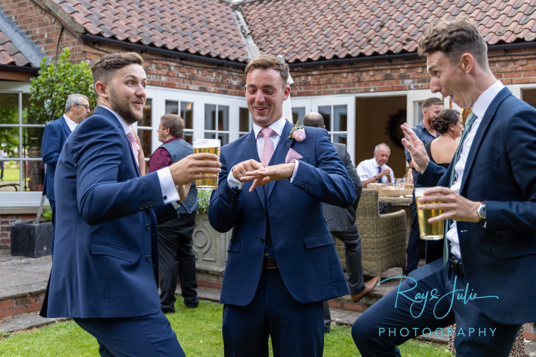 Groom showing off his wedding ring to wedding guests