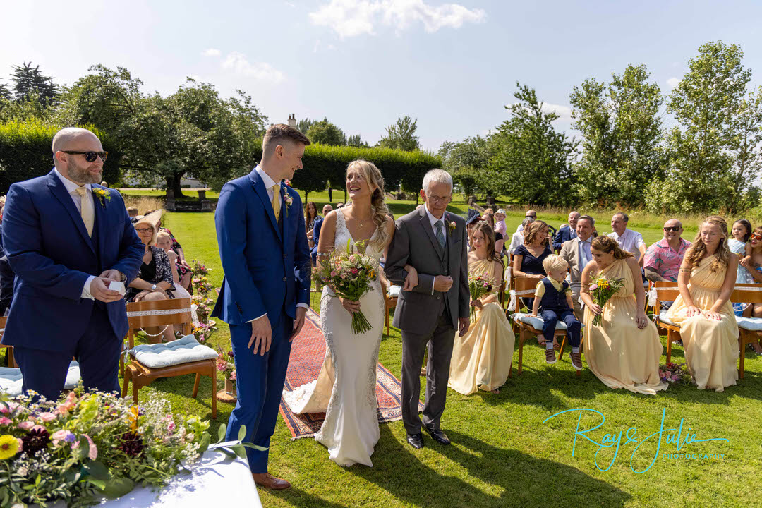 Bride and Groom smiling at each other at start of their wedding ceremony