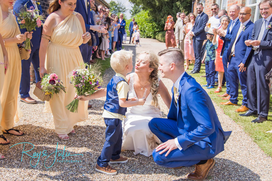 Bride and groom smiling at their son