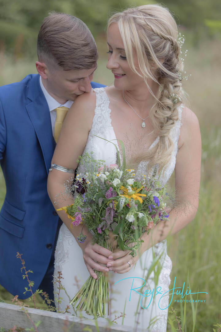 Beautiful bridal couple portrait. Bride holding wedding bouquet