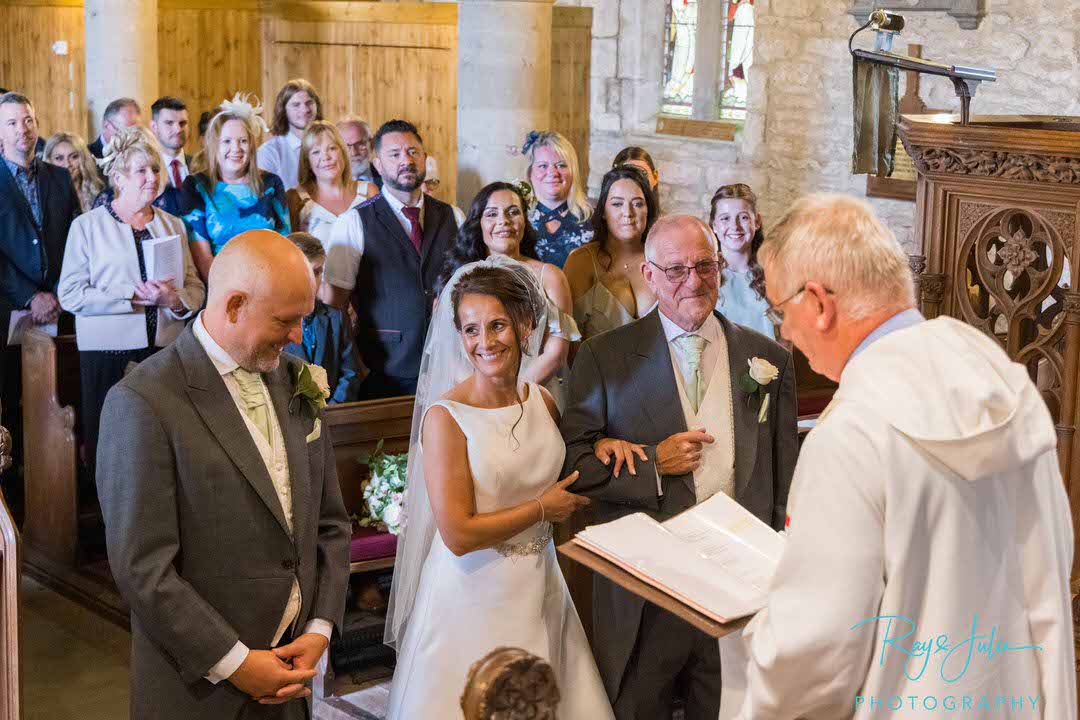 Bride smiling at groom at front of church at St Peters Church East Yorkshire