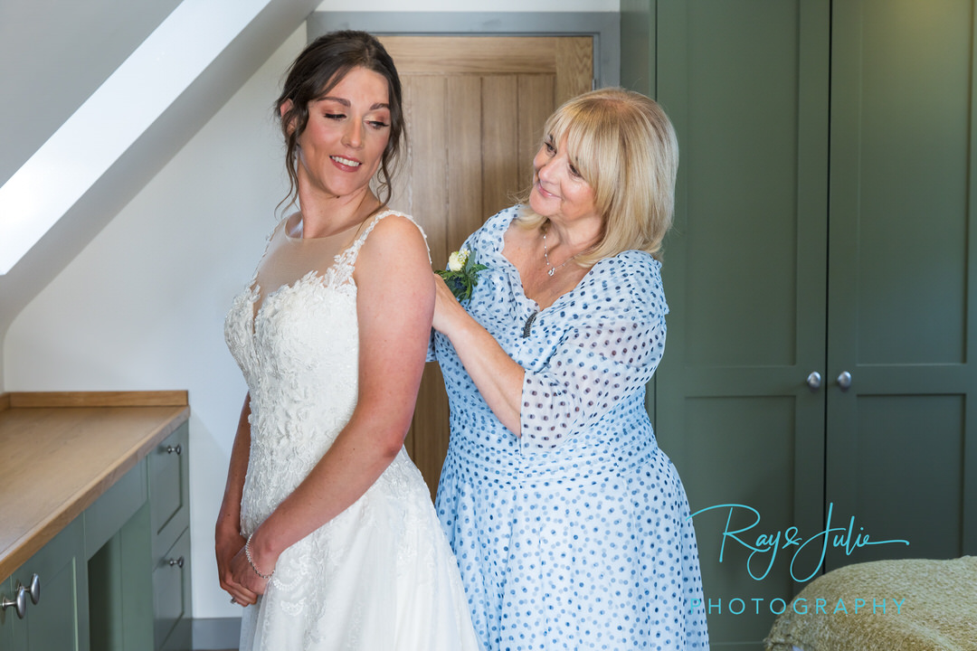 Proud mum doing up her daughters wedding dress - East Yorkshire Wedding Photography